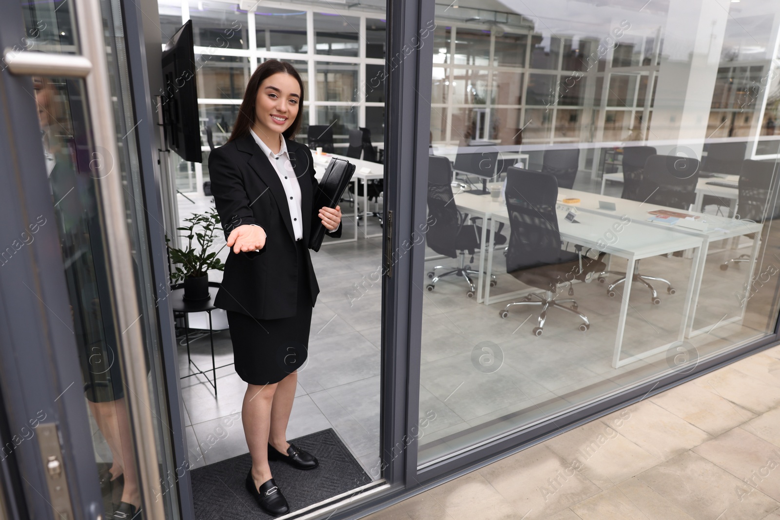 Photo of Happy real estate agent with leather portfolio in office