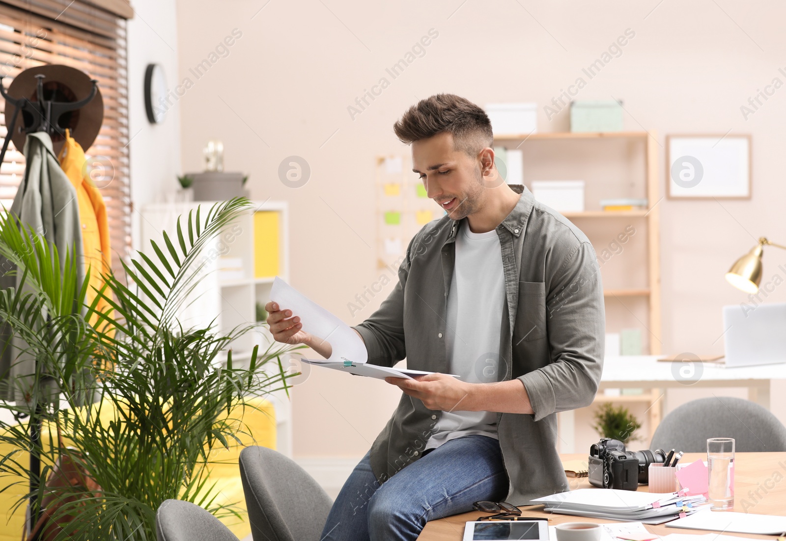 Photo of Journalist with papers at workplace in office