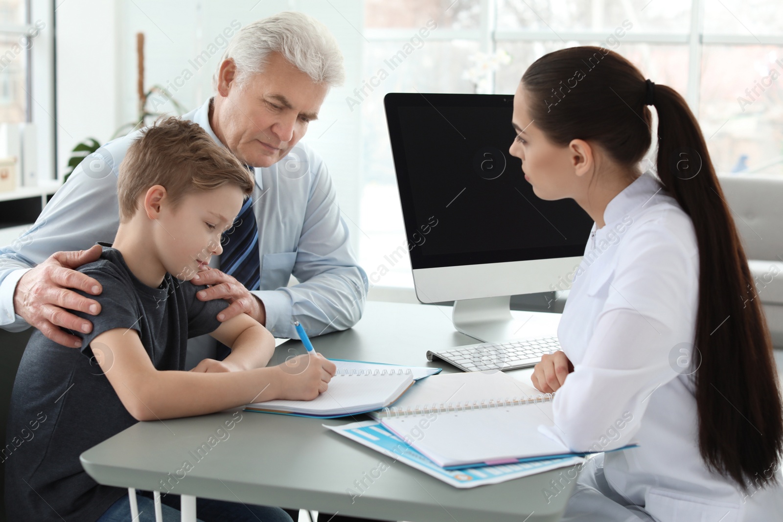 Photo of Senior man with his grandson having appointment at child psychologist office