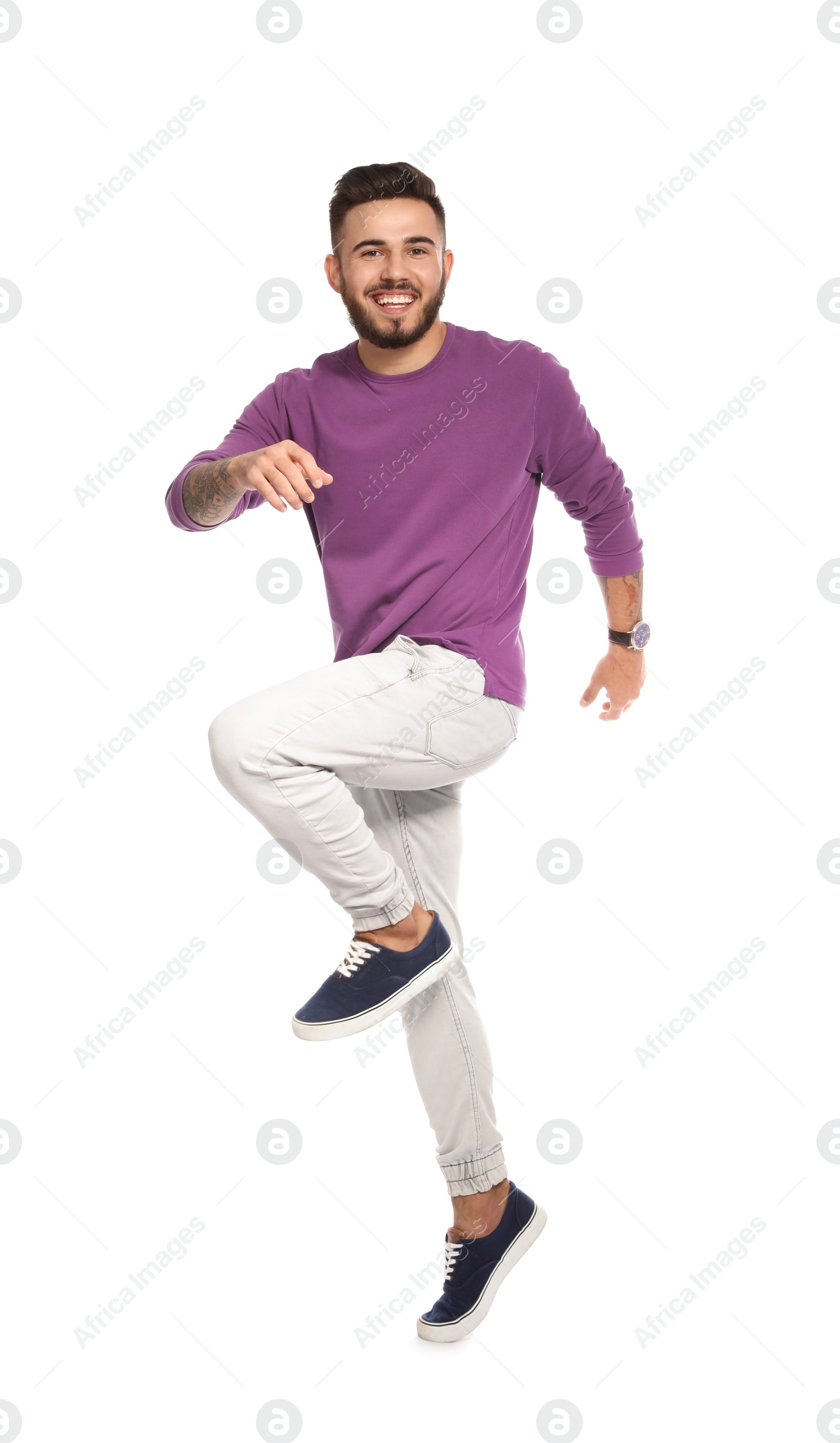 Photo of Handsome young man jumping on white background