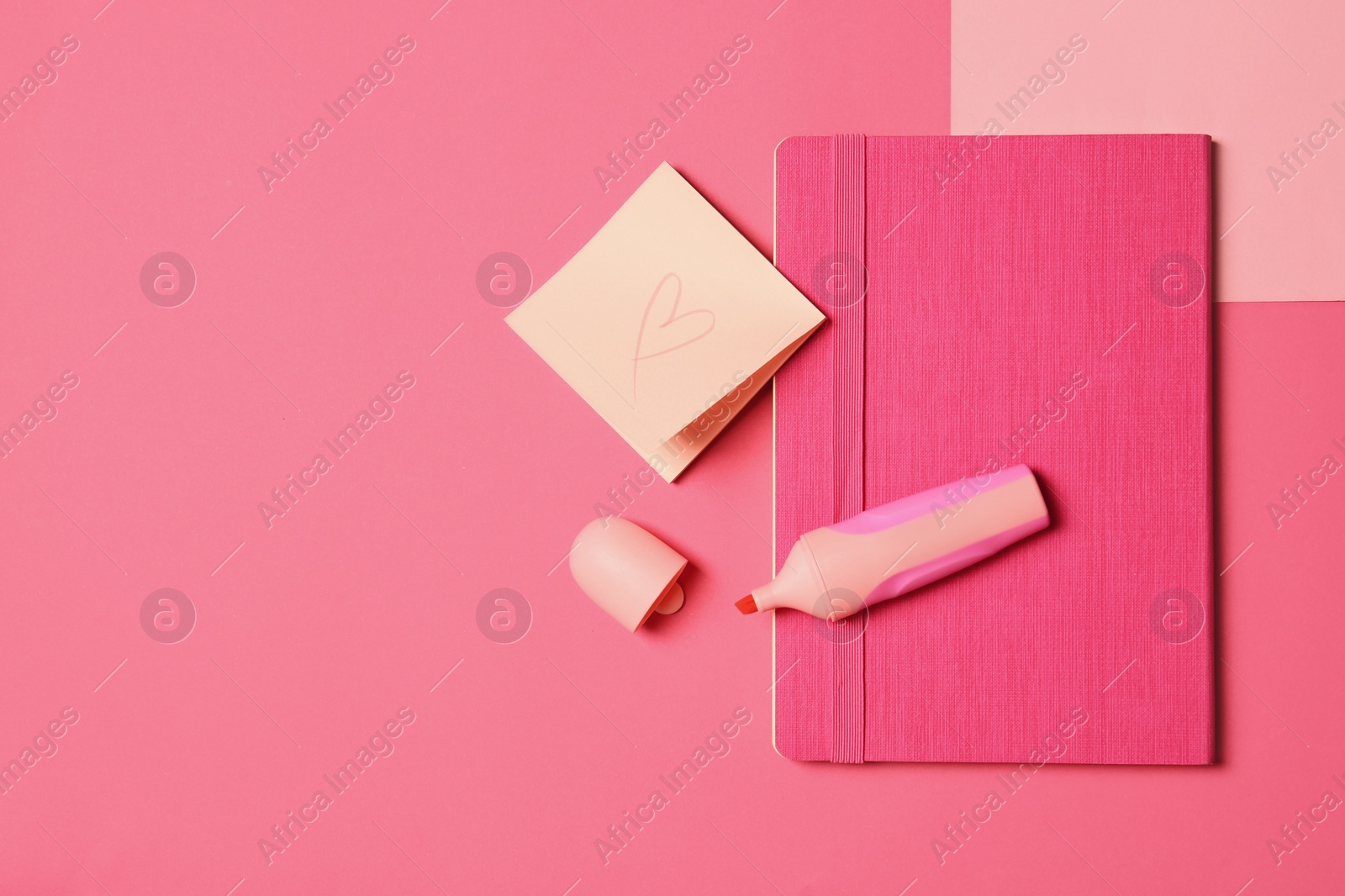 Photo of Bright notebook, marker, note paper with heart and cap on pink background, flat lay. Space for text