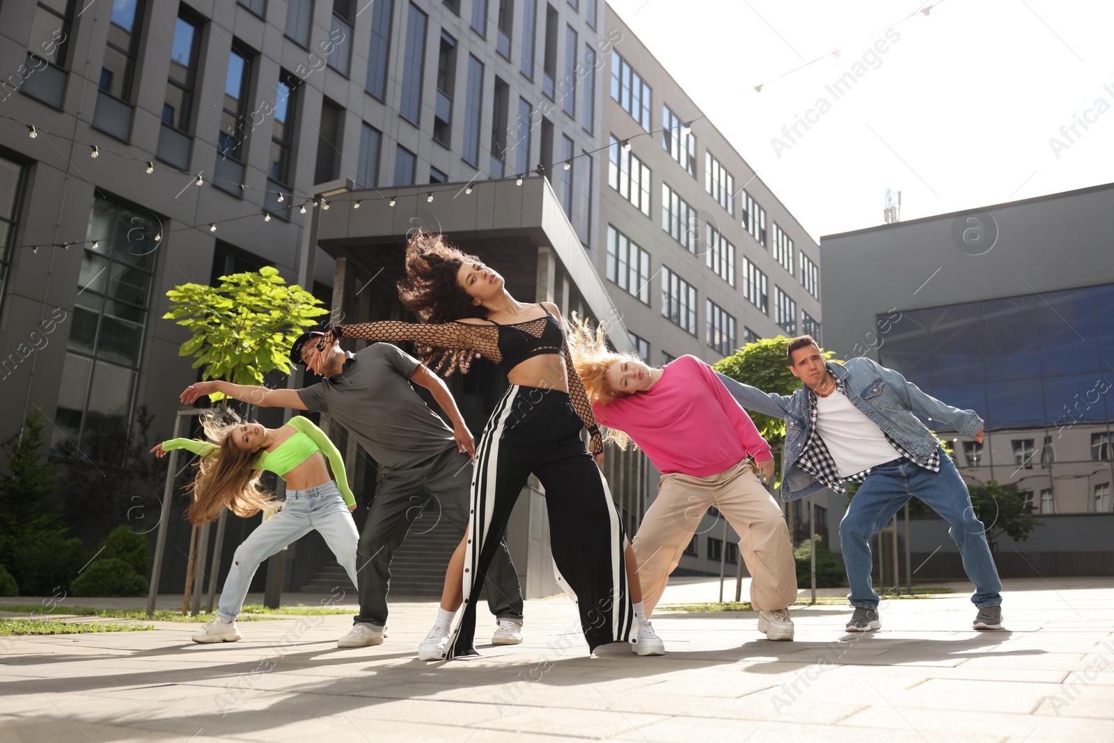 Photo of Group of people dancing hip hop outdoors, low angle view