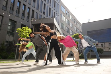 Photo of Group of people dancing hip hop outdoors, low angle view