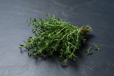 Photo of Bunch of aromatic thyme on black table