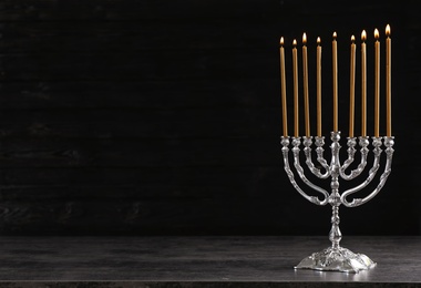 Photo of Hanukkah menorah on table against dark background