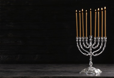 Hanukkah menorah on table against dark background