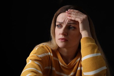 Portrait of sad woman on black background