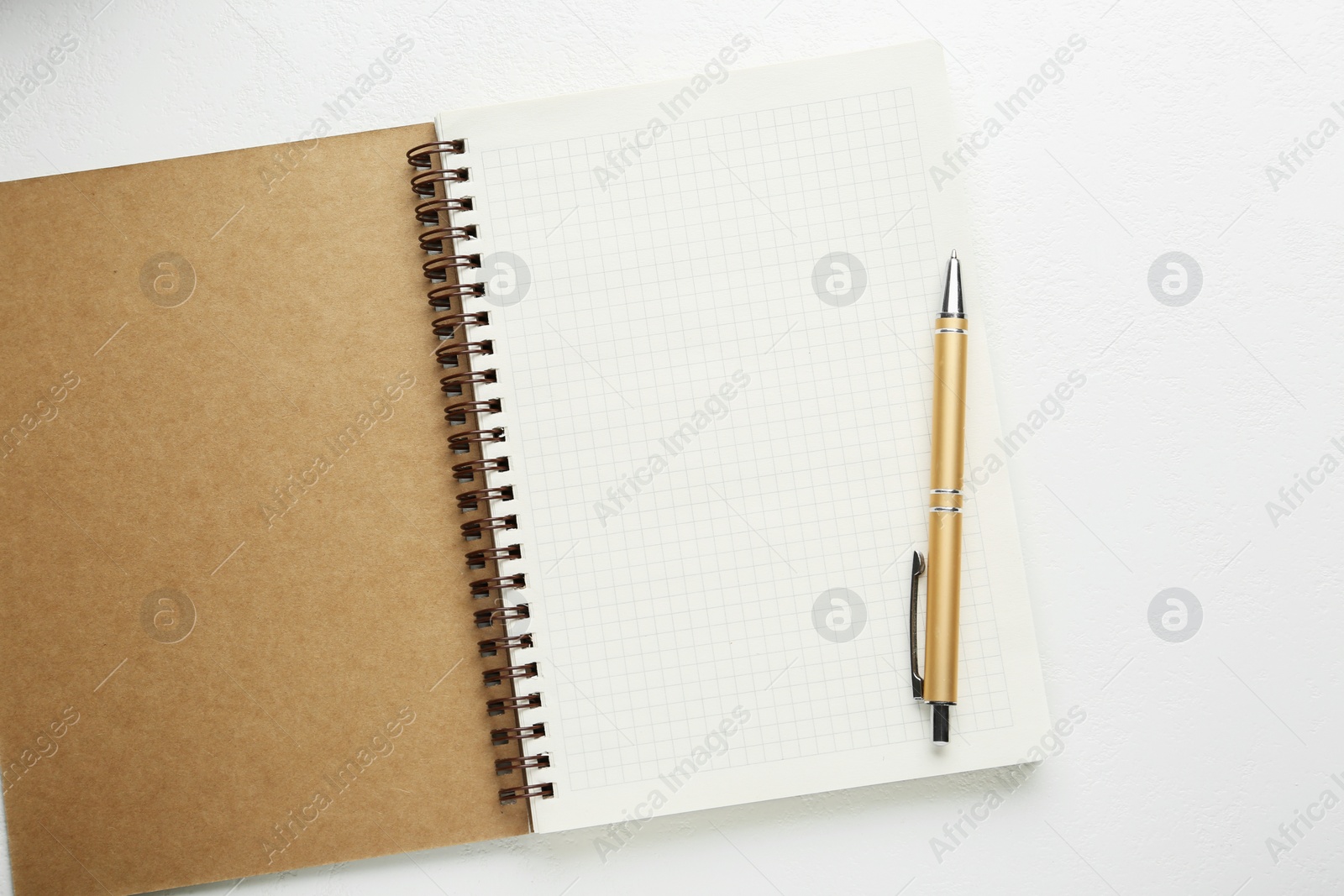 Photo of Open notebook and pen on white table, top view. Space for text