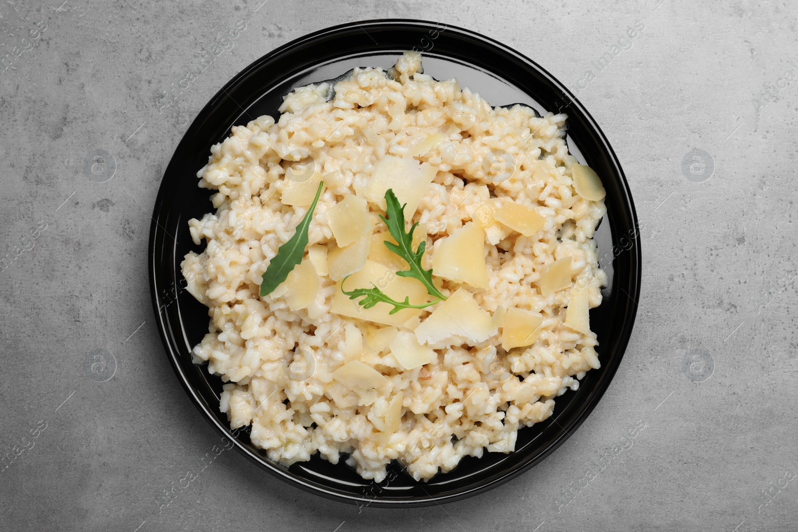 Photo of Delicious risotto with cheese on grey table, top view