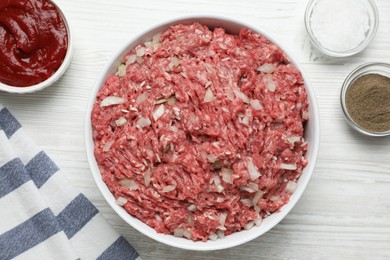 Meat filling in bowl for stuffed cabbage rolls on white wooden table, flat lay