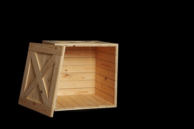 Photo of Wooden crate on black background. Space for text