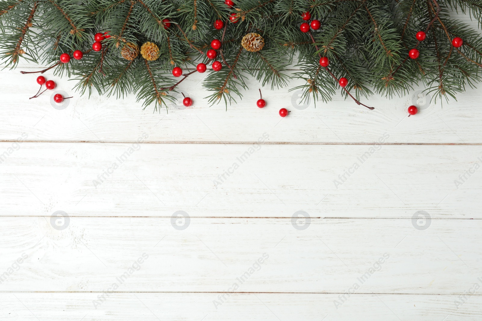 Photo of Flat lay composition with fir branches and berries on white wooden background, space for text. Winter holidays