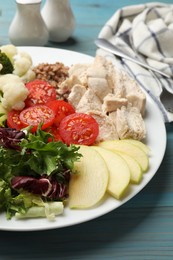 Photo of Balanced diet and healthy foods. Plate with different delicious products on blue wooden table, closeup