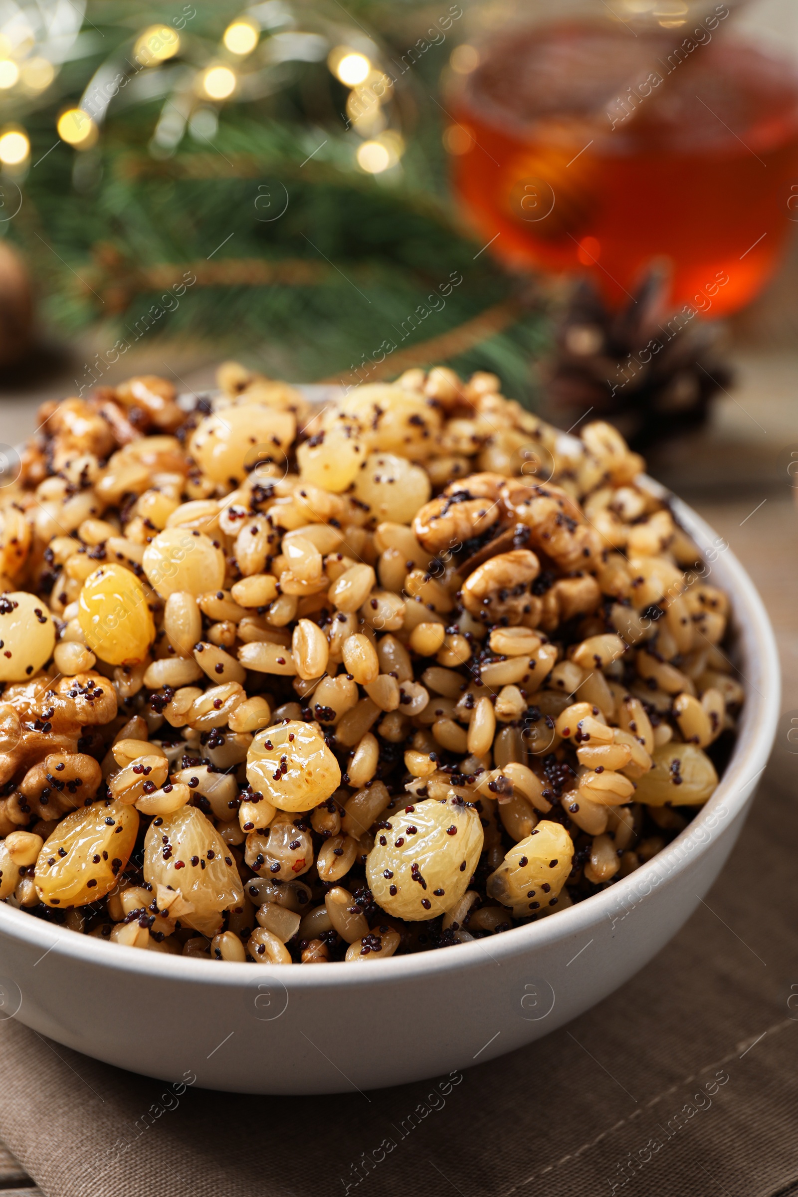 Photo of Traditional Christmas slavic dish kutia in bowl on napkin, closeup