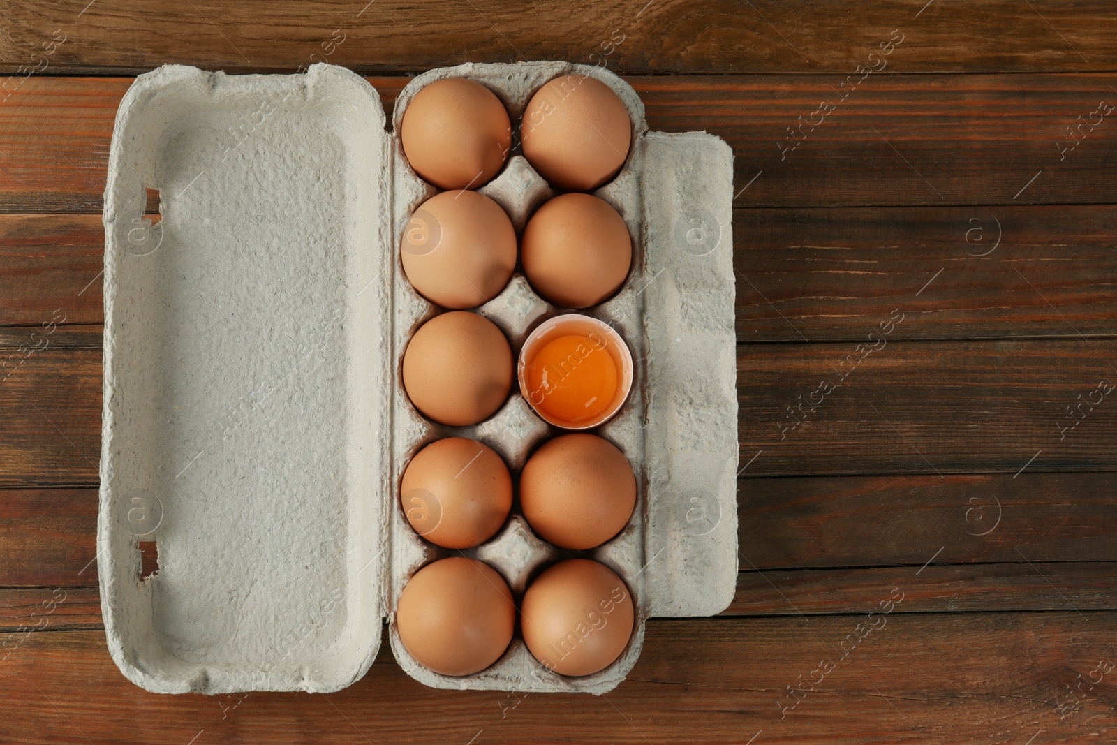 Photo of Raw chicken eggs on wooden table, top view