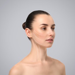 Image of Attractive woman with perfect skin after cosmetic treatment on grey background. Lifting arrows on her face