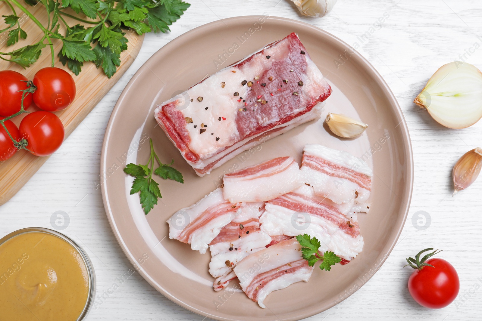 Photo of Tasty salt pork with parsley served on white wooden table, flat lay