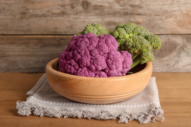 Photo of Plate with different cabbages on wooden table. Healthy food