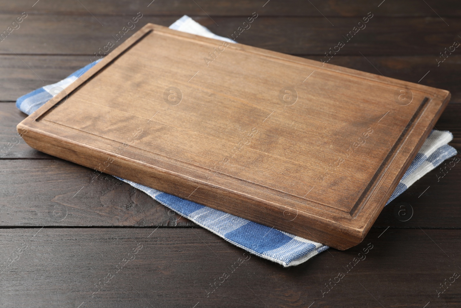 Photo of Kitchen towel and cutting board on wooden table