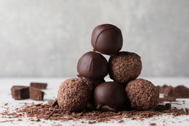 Photo of Many delicious chocolate truffles on light table