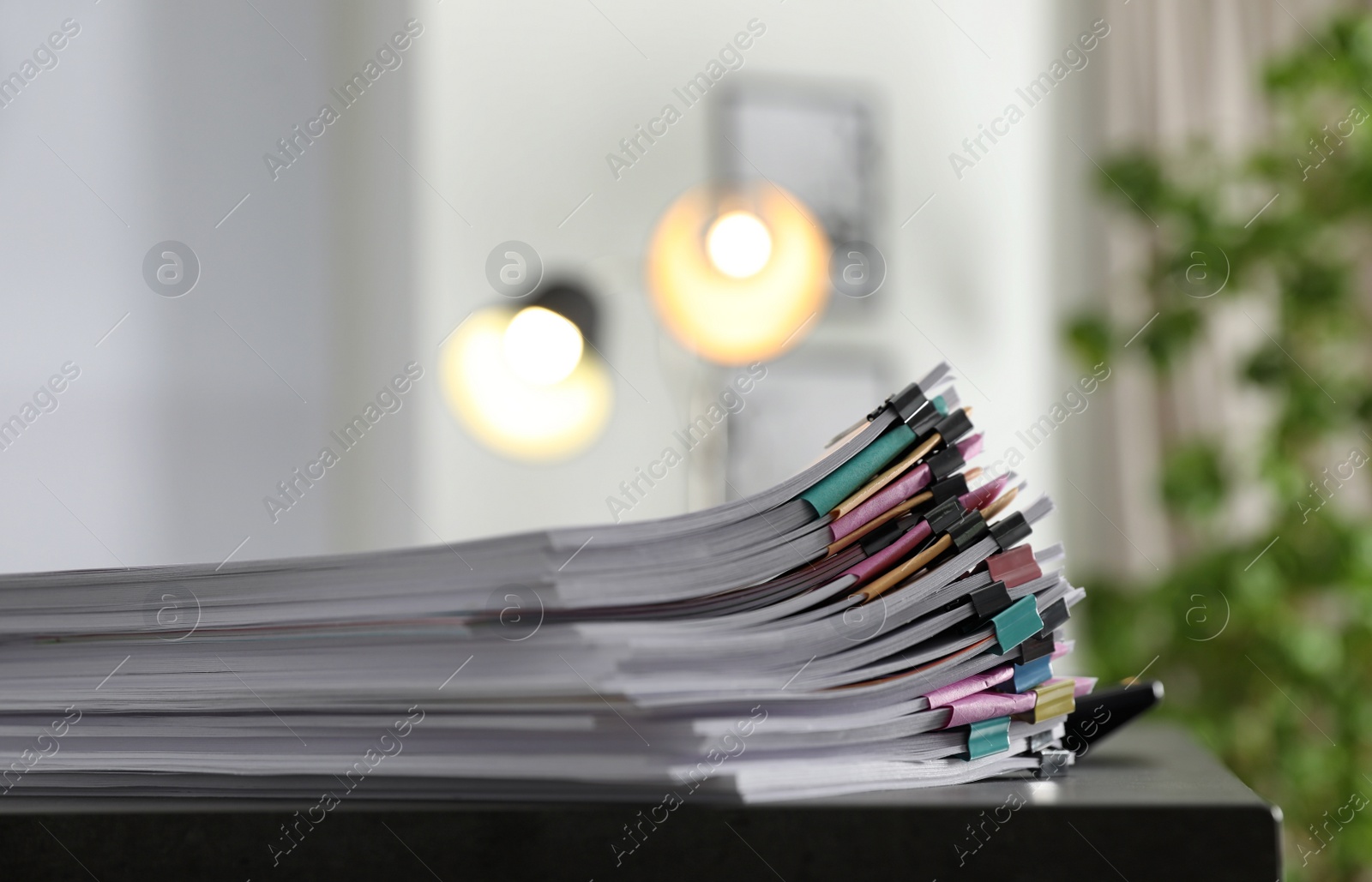 Photo of Stack of documents with paper clips on office table. Space for text