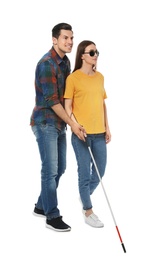 Photo of Man assisting blind woman with long cane on white background