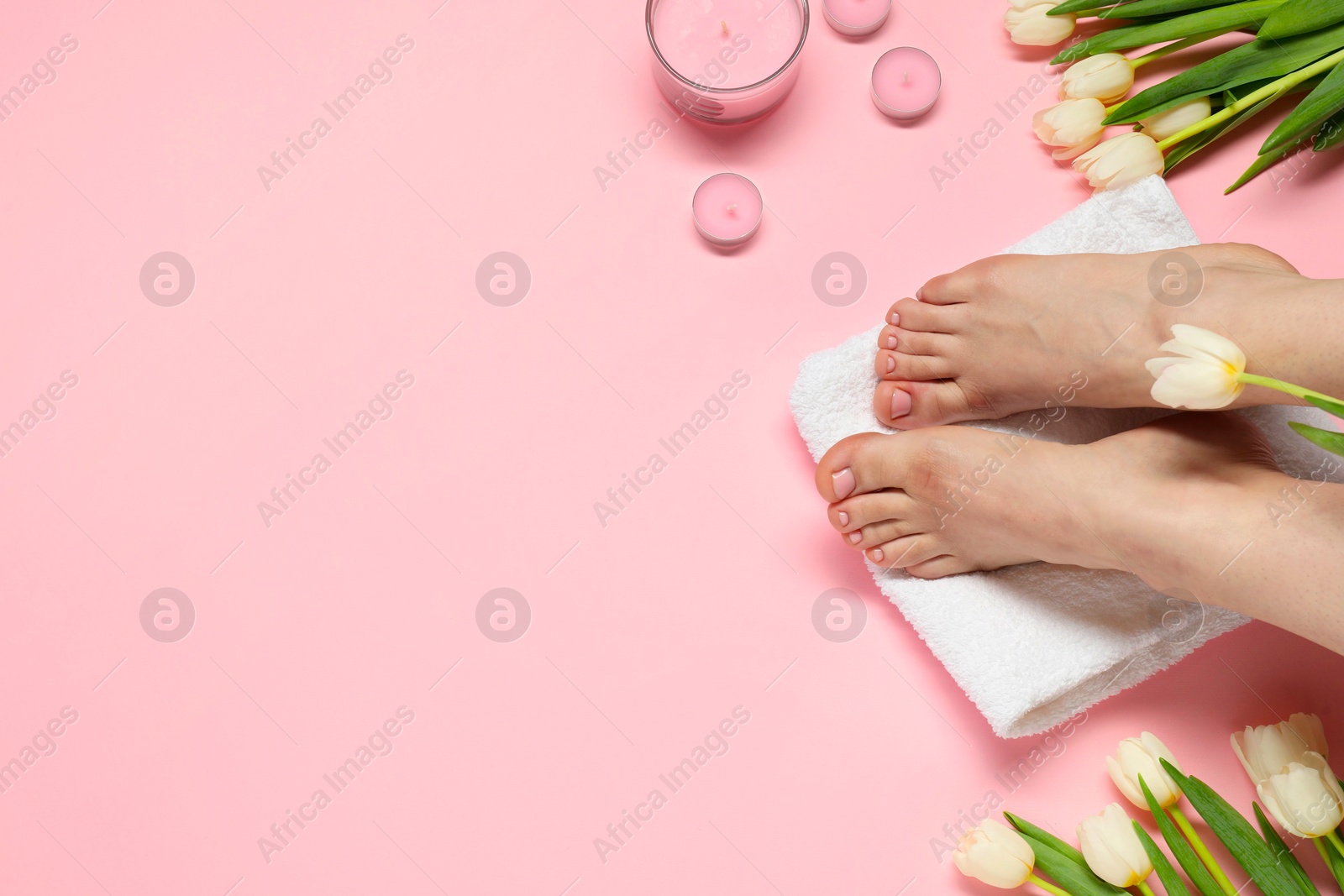 Photo of Closeup of woman with neat toenails after pedicure procedure on pink background, top view. Space for text