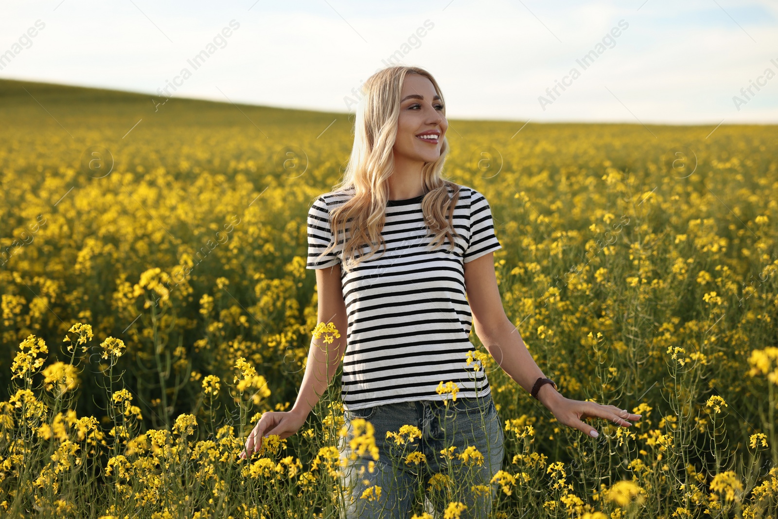 Photo of Portrait of happy young woman in field on spring day