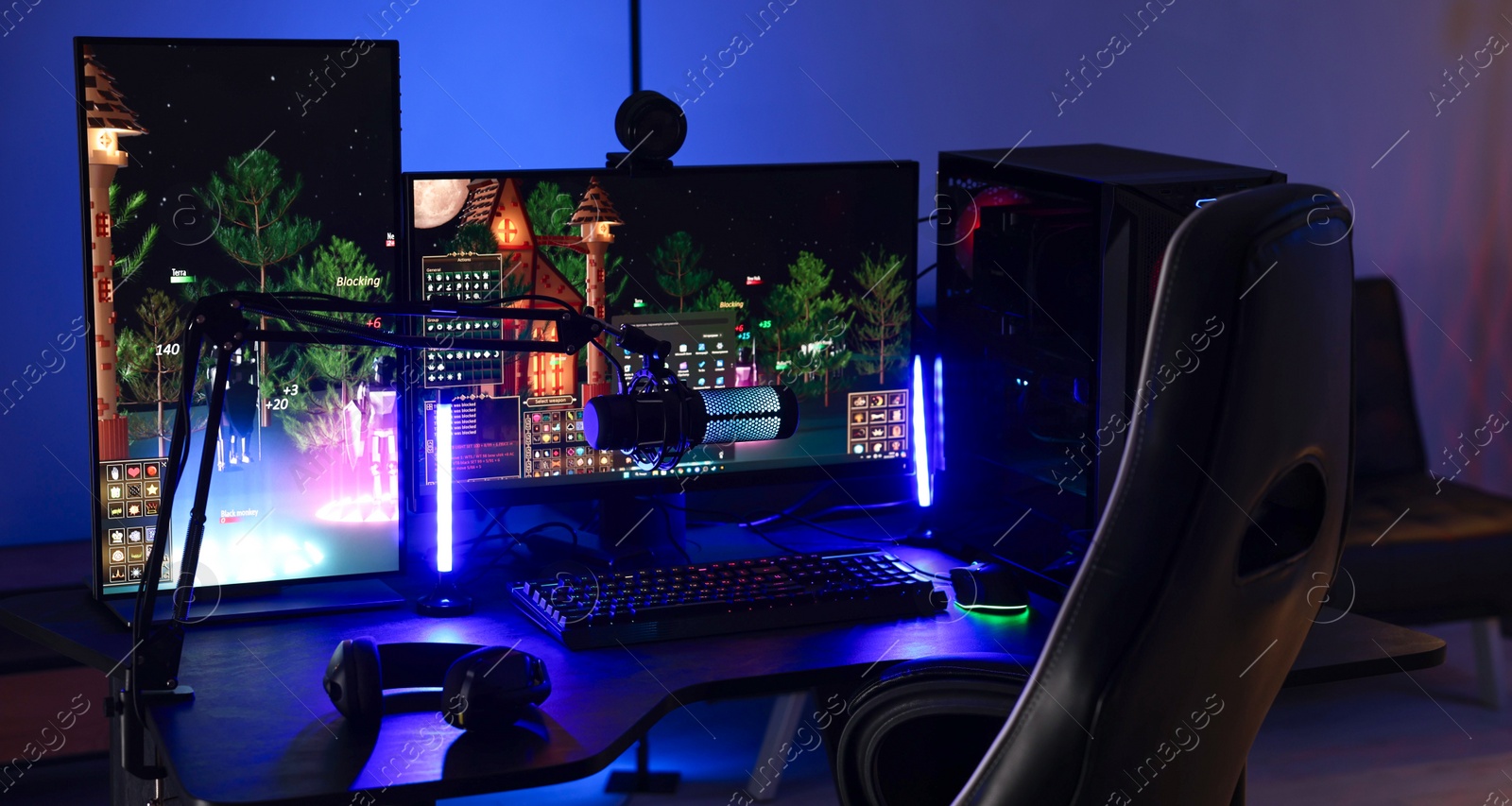 Photo of Playing video games. Stylish room interior with modern computer and gaming chair in neon lights