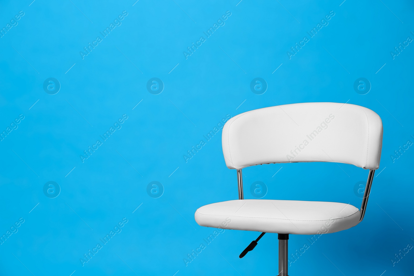 Photo of Comfortable office chair on light blue background, space for text