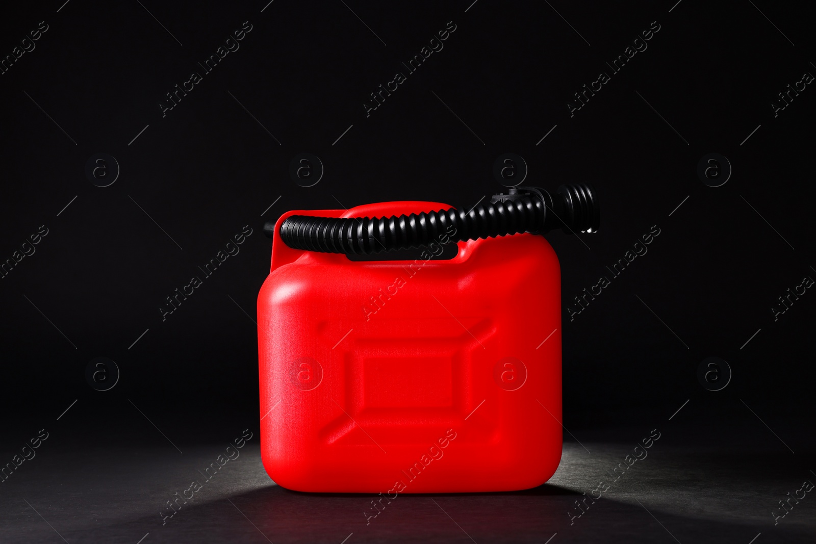 Photo of New red plastic canister on black background