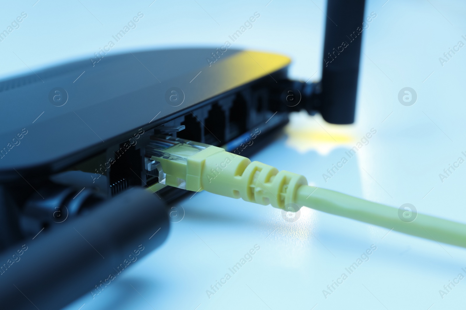 Photo of Connected cable to router on white table, closeup. Wireless internet communication