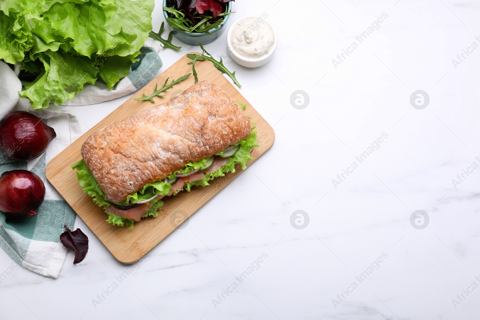 Photo of Delicious sandwich with salmon and ingredients on white table, flat lay. Space for text