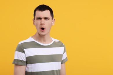 Portrait of surprised man on orange background, space for text