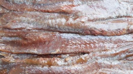 Photo of Canned anchovy fillets as background, closeup view