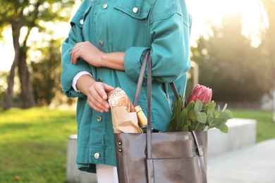 Woman with leather shopper bag in park, closeup
