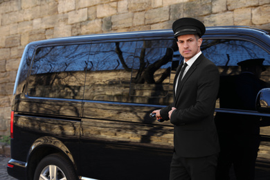 Photo of Driver opening door of luxury car. Chauffeur service