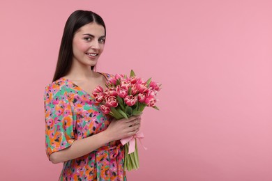 Photo of Happy young woman with beautiful bouquet on dusty pink background. Space for text