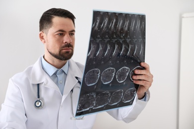Photo of Professional orthopedist examining X-ray picture in clinic