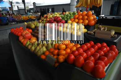 Barcode and tasty fresh fruits on counter at wholesale market