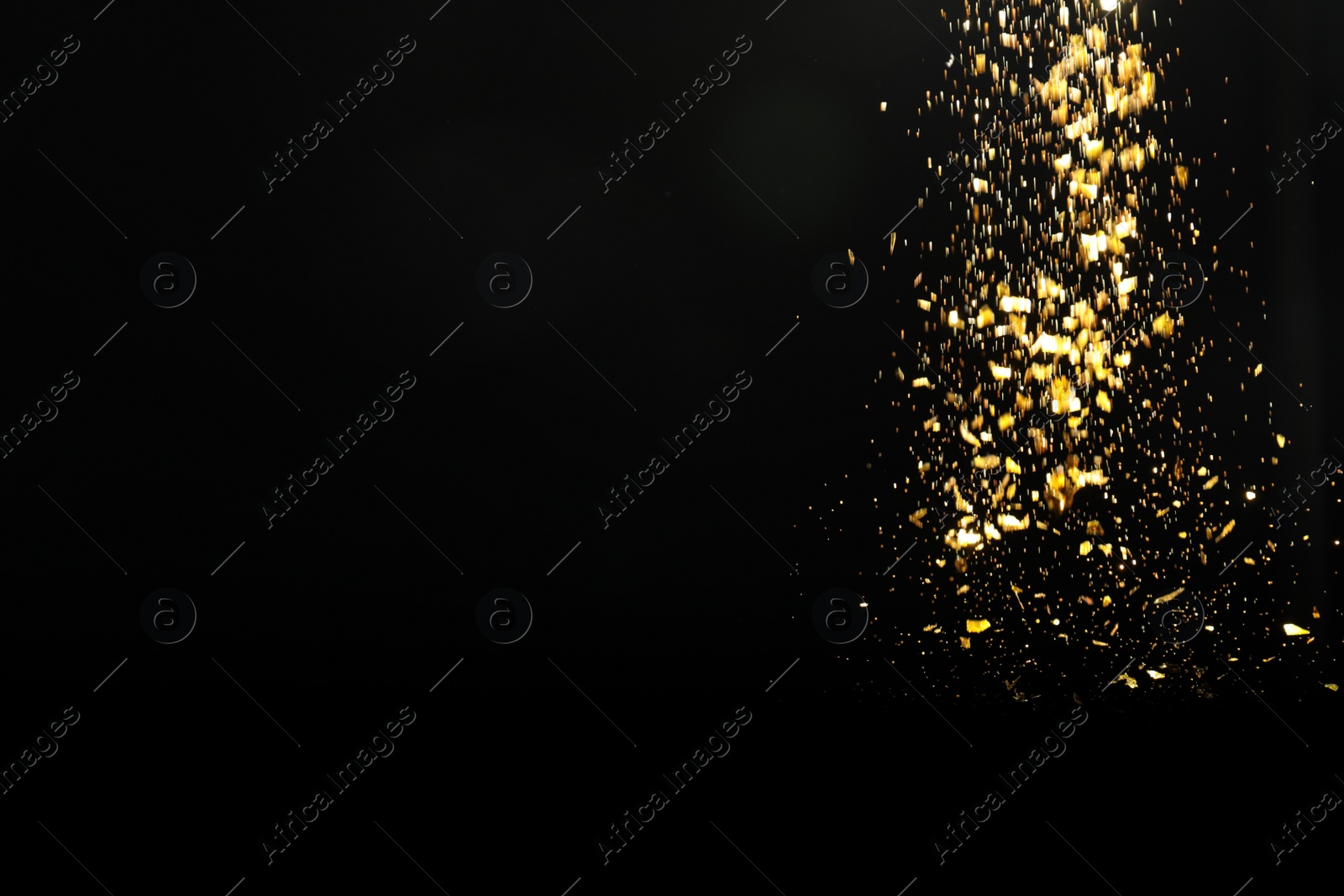 Photo of Shiny golden glitter falling down on black background, space for text. Bokeh effect