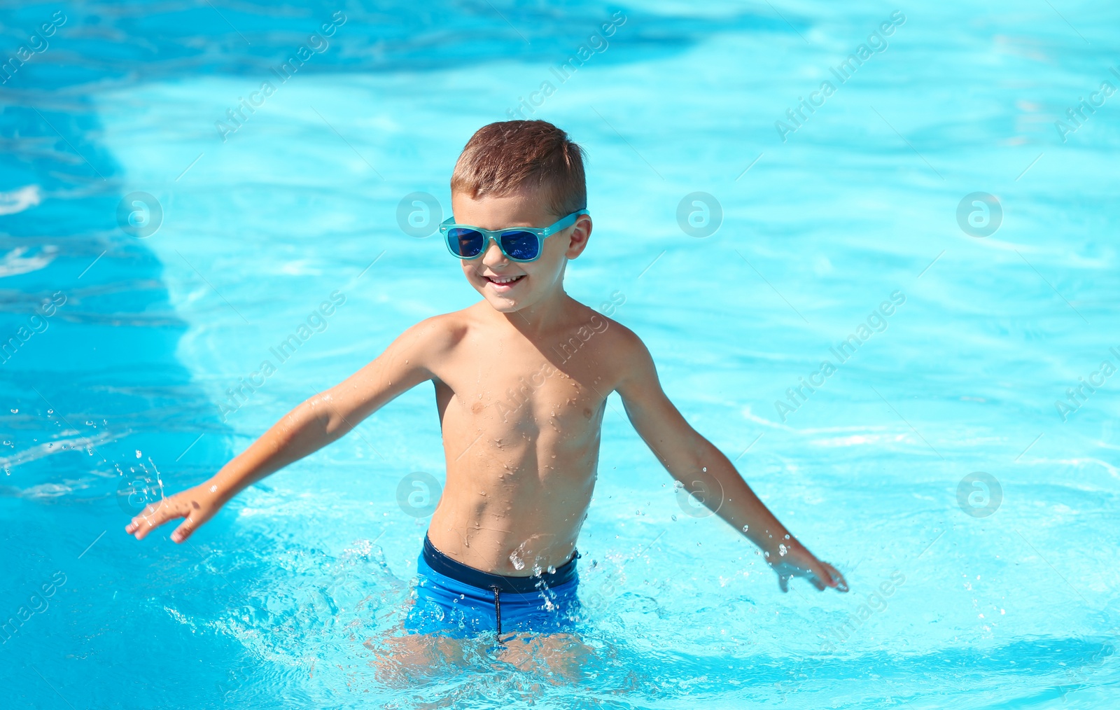 Photo of Happy little boy having fun in swimming pool