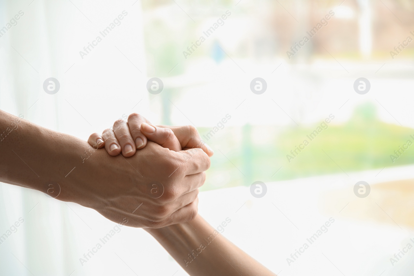 Photo of Man and woman holding hands together on light background. Unity concept