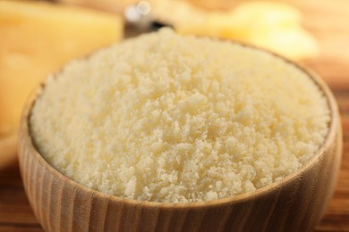 Photo of Bowl with grated parmesan cheese on table, closeup