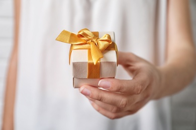 Woman holding beautiful gift box, closeup