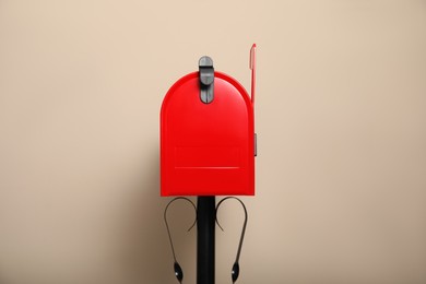 Photo of Closed red letter box against beige background