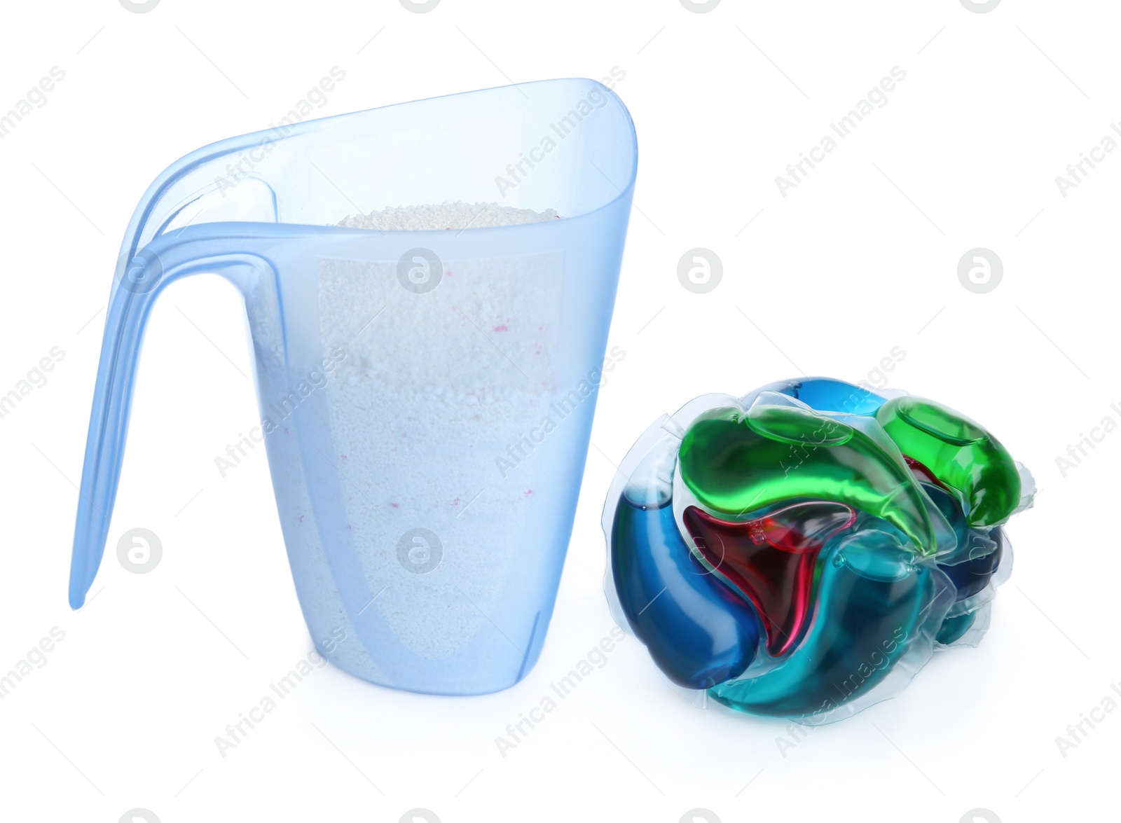 Photo of Laundry capsules and measuring cup of washing powder on white background