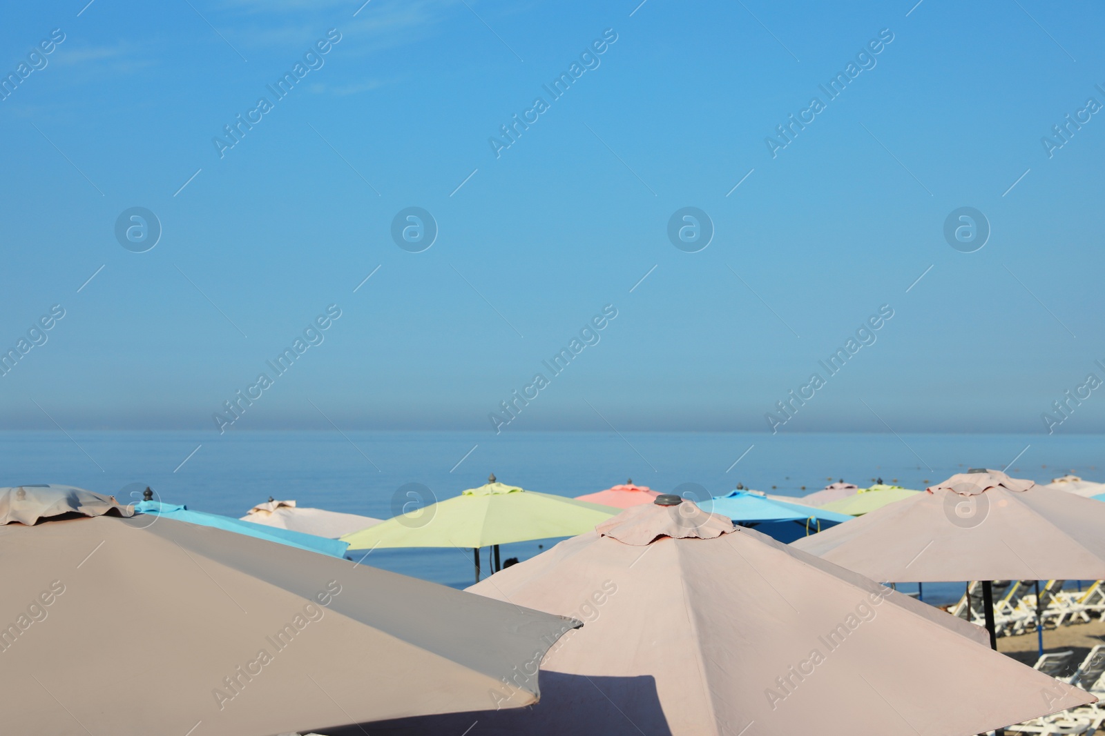 Photo of Many beach umbrellas at resort on sunny day