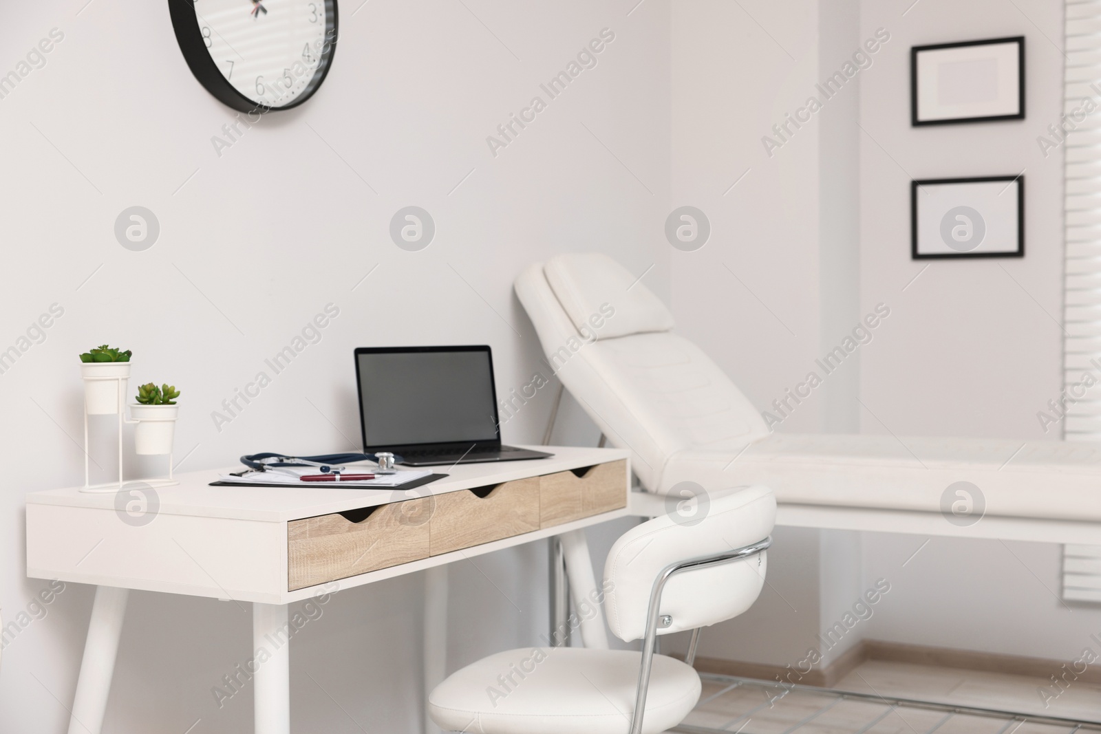 Photo of Modern medical office with doctor's workplace and examination table in clinic