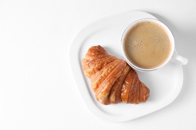 Photo of Breakfast time. Fresh croissant and coffee on white background, top view. Space for text